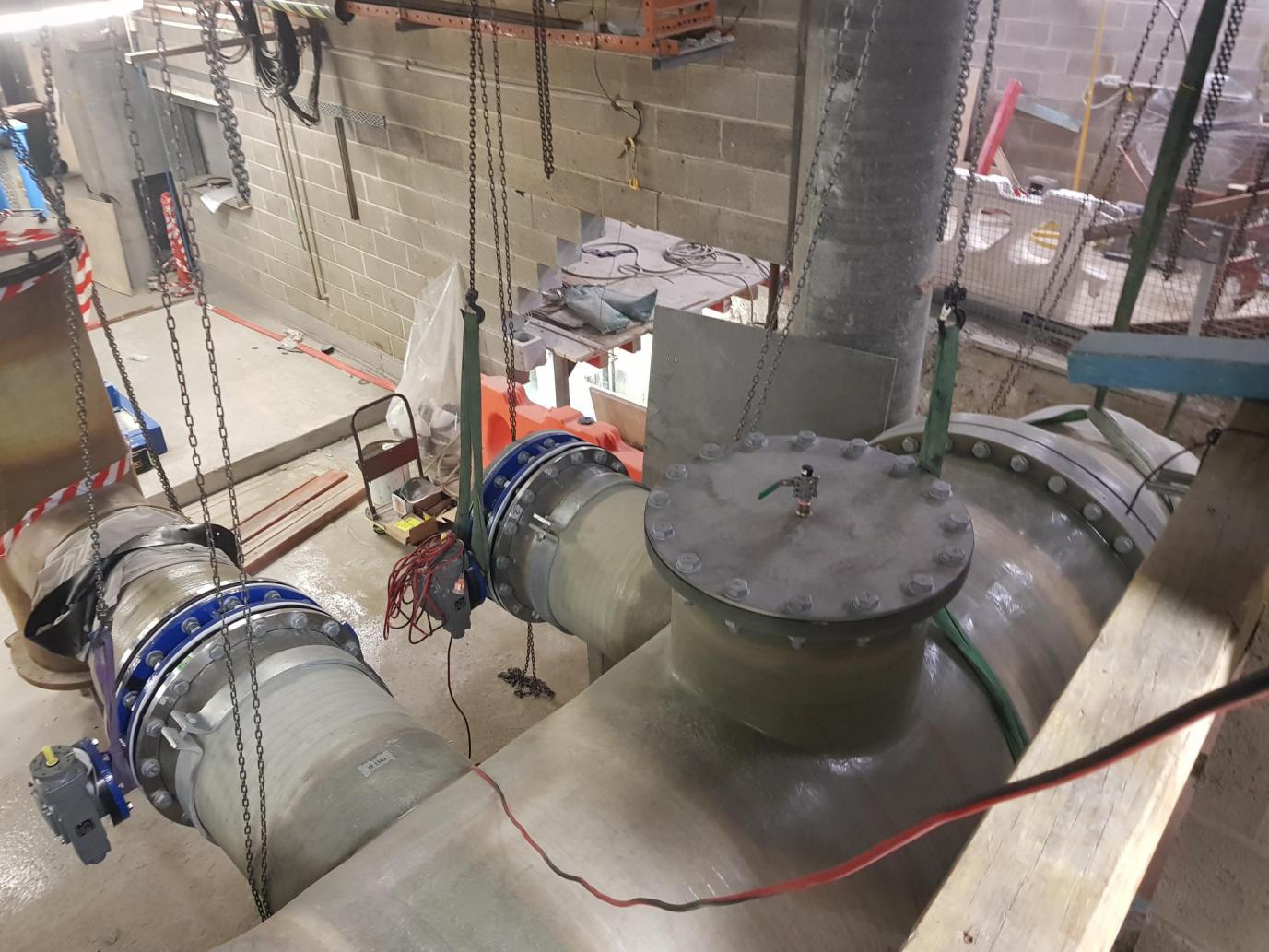 Seawater GRP header sections are rigged into final position